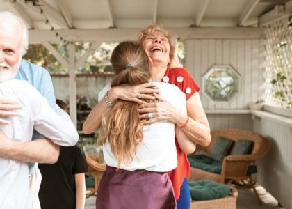 A heartwarming reunion with family members hugging and smiling in a cozy indoor setting.