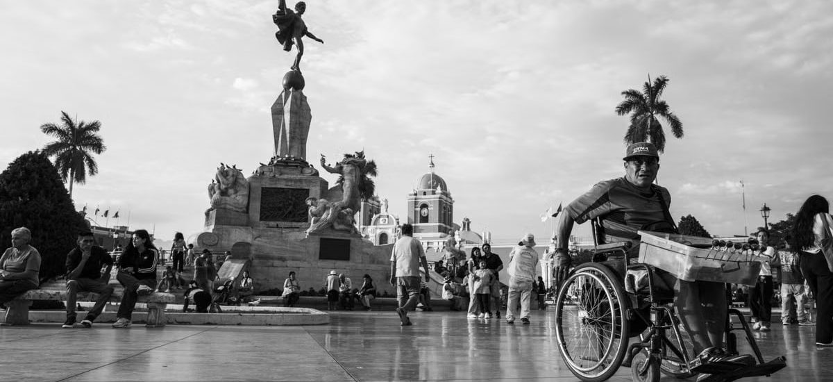 A bustling scene in Trujillo's main square capturing daily life and architectural beauty in black and white.