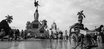A bustling scene in Trujillo's main square capturing daily life and architectural beauty in black and white.